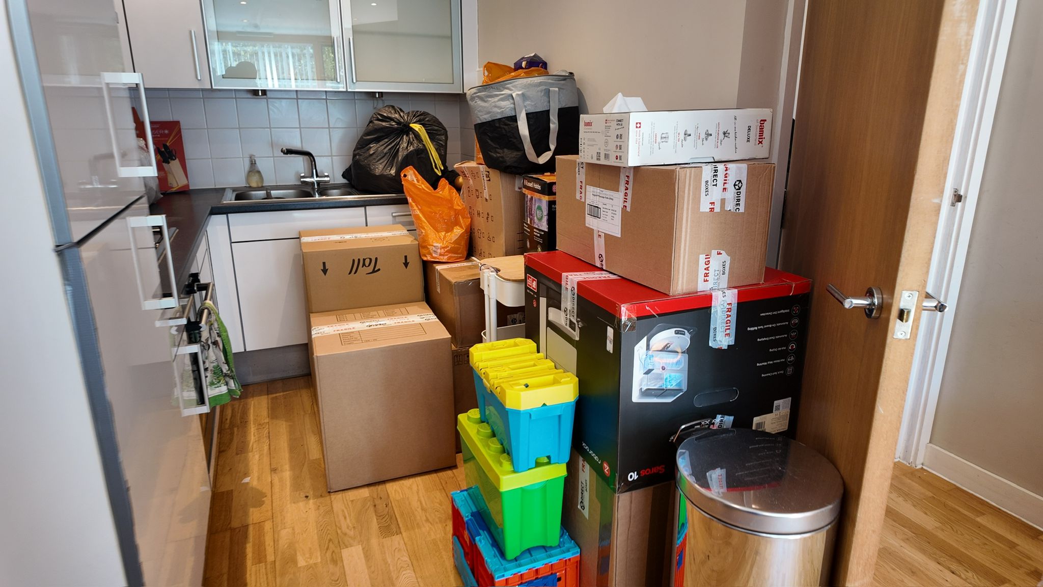 Fully packed and labelled kitchen ready for move day — fragile boxes stacked