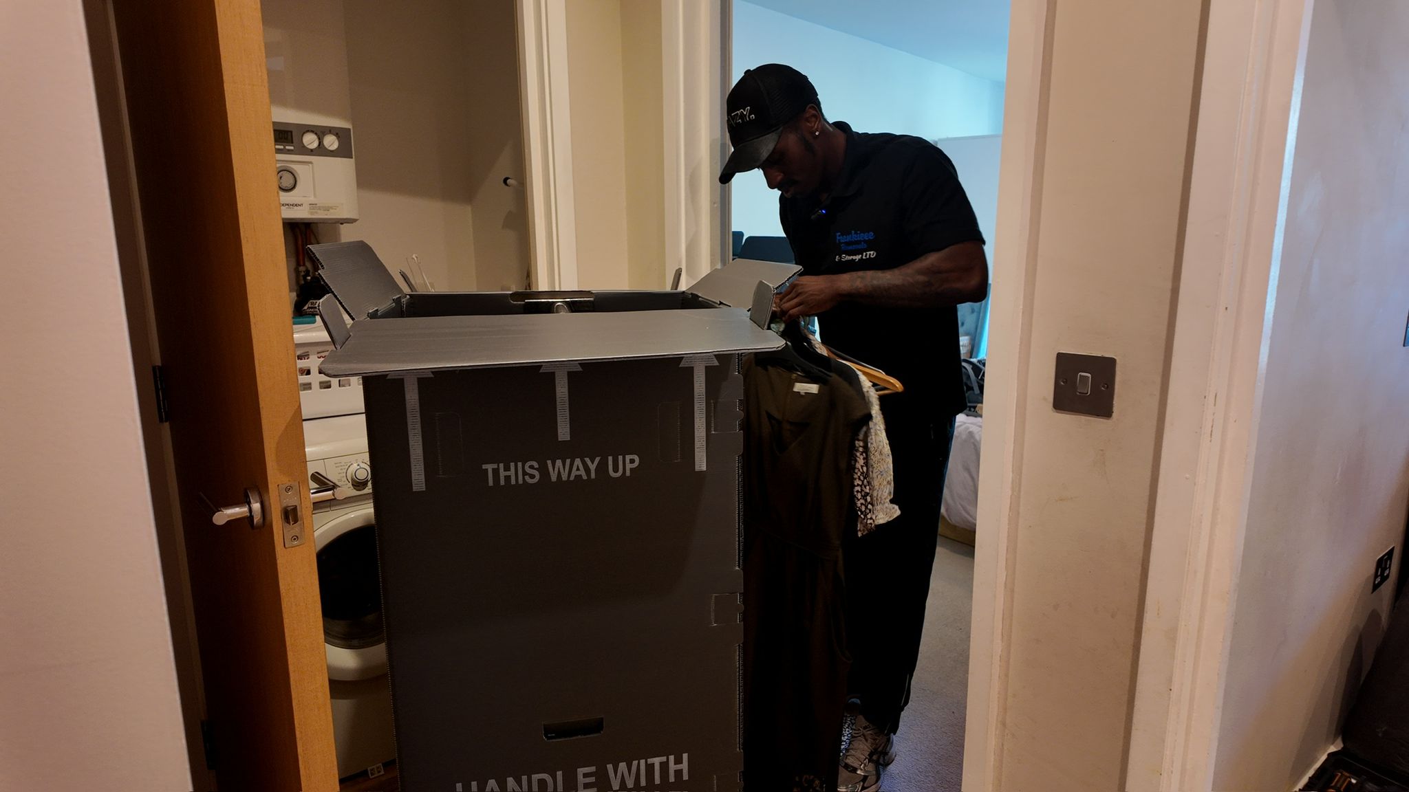 Specialist wardrobe box being packed with hanging clothes